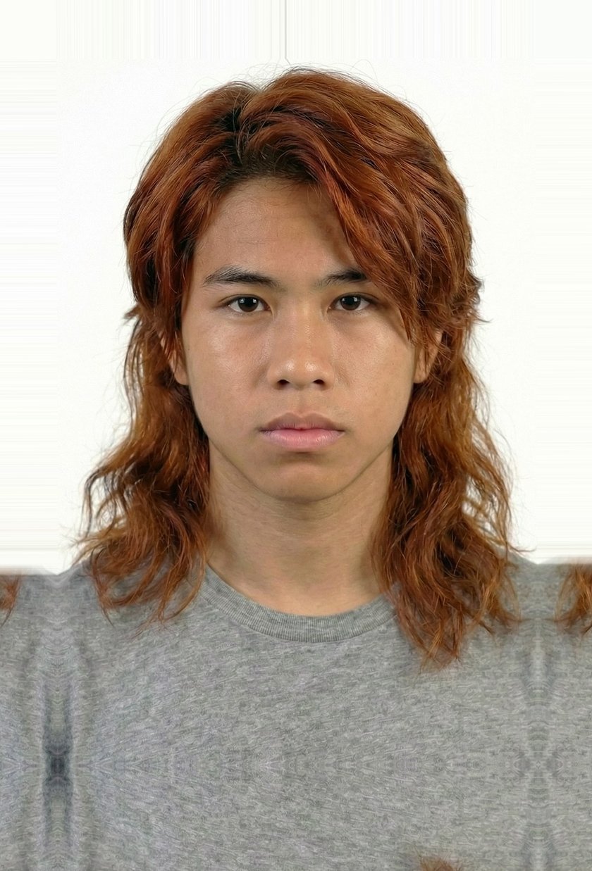 Ethan Flores as a teenager, long auburn hair, grey t-shirt